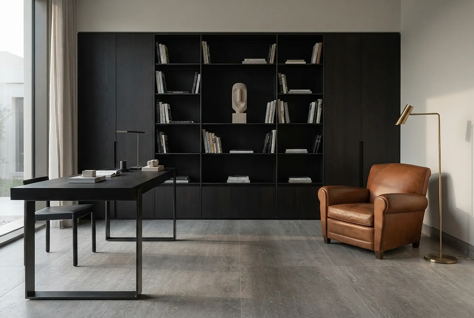 Study with dark shelving and leather armchair